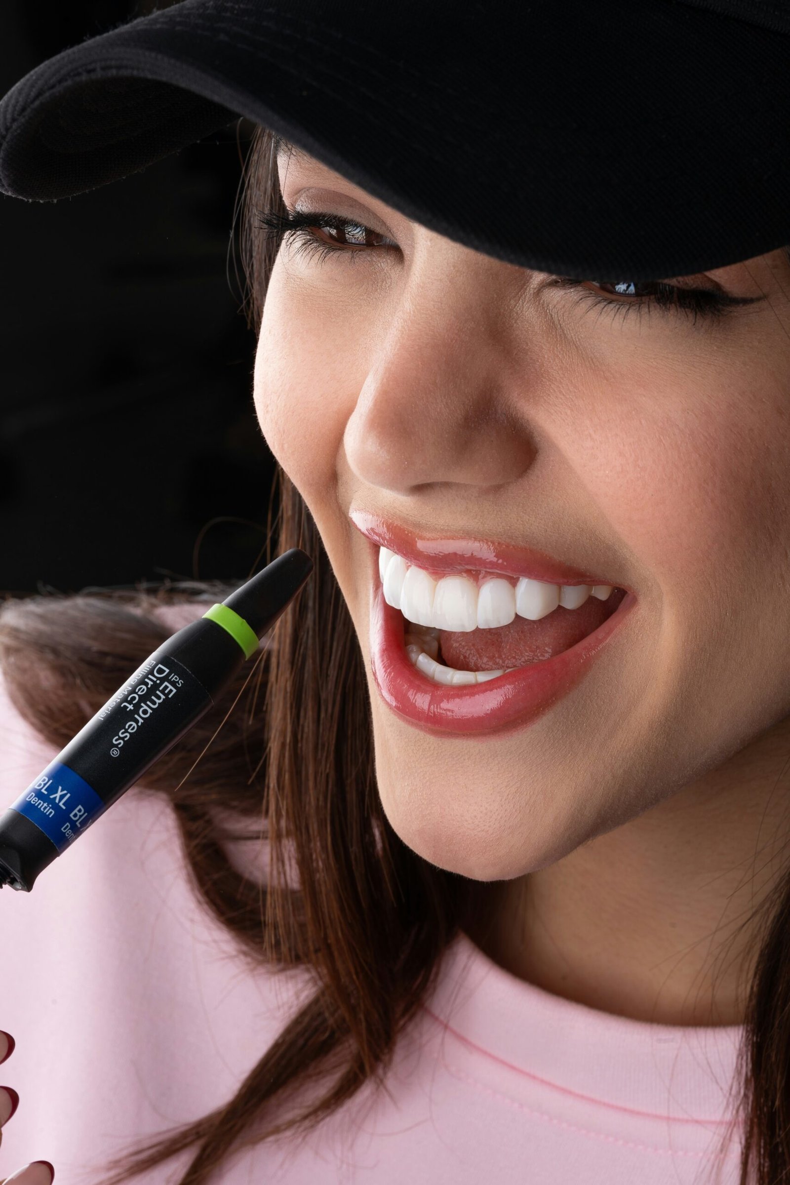 Smiling woman showcasing perfect, bright teeth after veneers. 