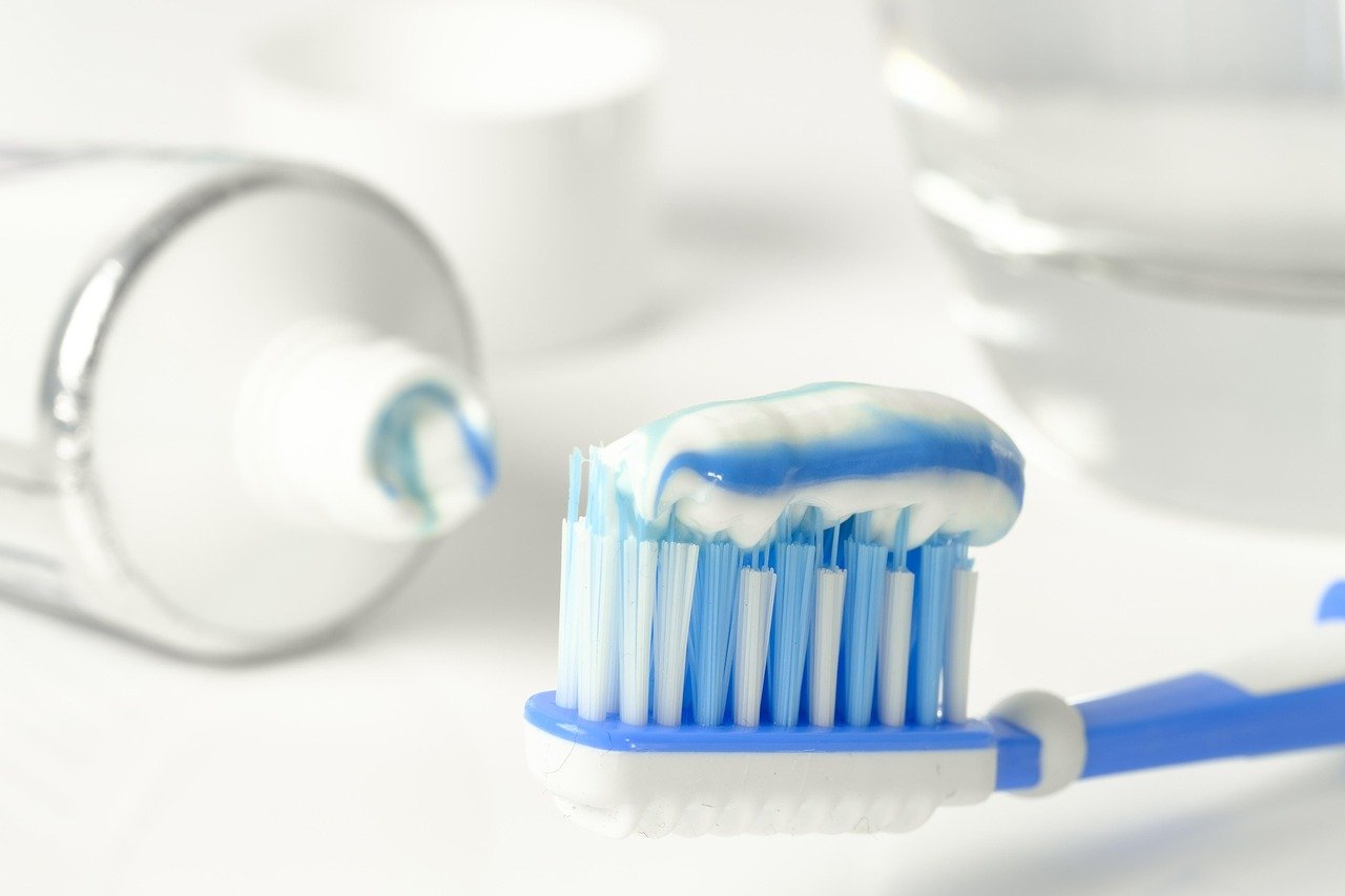 Close-up of a toothpaste tube containing fluoride, essential for oral health.
